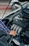 A young man checking and maintaining the engine of his car. Open the hood, check the engine safety before long-distance driving,