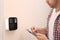 Young man checking security alarm system indoors