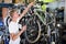 Young man checking tire on cycle wheel indoors