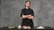 Young man chef cook in black clothes on a gray background. Kitchen table, ingredients for Japanese sushi and rolls.