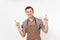 Young man chef or waiter in striped brown apron, shirt pointing fingers up on copy space isolated on white background