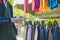 Young man choosing which tie to buy at local market. Many various pattern colorful neckties hanging on clothes rack.  Colorful tie