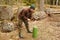 Young man chops wood with an ax in the forest. Guy chops a tree into logs with an cleaver in natura