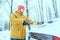 Young man clean car after snow storm