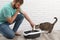 Young man cleaning cat litter tray