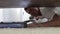 Young man cleaning a floor under a bed lying on the floor using vacuum cleaner