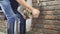 Young man cleaning the hooves of horses indoor. Blacksmith cleans and trims a horse hoof at stabled. Male hands is