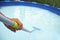 Young man cleaning a portable swimming pool