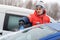 The young man cleans the snow from the windshield of the car, the young man frees the line of the car from the snow