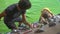 A young man climbing instructor teaching little boy how to climb the wall in a bouldering climbing gym