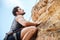 Young man climbing a steep wall in mountain