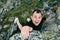 Young man climbing a steep wall in mountain. Rock-climb extreme sport. Tourist man hiking and climbing at mountains. Summer travel