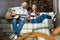 Young man with closed eyes playing guitar near smiling woman with wine glass