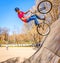 a young man commits a bicycle jump in a city park on a spring sunny day