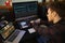 Young Man Composing Music on Laptop Computer in Bedroom