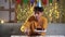 Young man in cone hat putting candles in cake celebrating birthday at home