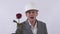 Young man in construction hat and classical suite give a long red rose in white background