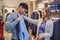 Young man consults with girlfriend while selecting a shirt