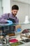 Young man cooking pita gyros sandwich for take away. The cook preparing traditional Greek fast food dish in a European cafe