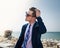 Young man corrects his hair on the background of the sea and sky