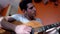 Young man on couch playing guitar at home