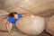 Young man creeps through cave