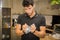 Young Man Crushing Plastic Water Bottle in Kitchen