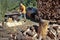 Young man cutting firewood, preparing for winter