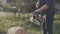 Young man cutting wood with chainsaw in yard