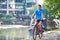 Young Man Cycling Next To River In Urban Setting