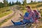 Young man cyclist sits on the edge of a dirt road