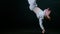 Young man dancer performing break dance trick in the dark studio