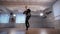 Young man dancing break dancing professionally in the dance studio. Dancer actively moving his arms. Boy with a serious