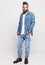 Young man in denim suit. Handsome man in denim jacket and jeans on a white background. Photo for advertising men`s jeans and