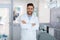 Young man dentist posing at dental cabinet