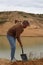 A young man digs a hole with a shovel