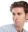 Young man, disgust and face looking over shoulder with anger, confused or frown against a white studio background