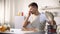 Young man disgusted with stinky meal on stove, spoiled ingredients, untasty food