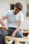 Young man in a diy project outside hammering a nail into a wooden structure