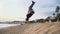 Young man doing acrobatic tricks on the beach.