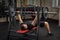 Young man doing bench press workout in gym