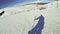 Young man doing a descent on a ski slope during a sunny day