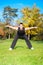 Young man doing exercise in autumn park