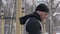 Young man doing pull up exercise on winter training on sport ground close up