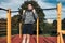 Young man doing pull-ups during his workout in a modern calisthenics street workout park