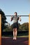 Young man doing pull-ups during his workout in a modern calisthenics street workout park