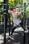 Young man doing pull ups on horizontal bar outdoors, workout, sp