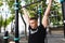 Young man doing pull ups on horizontal bar outdoors, workout, sport concept