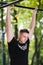 Young man doing pull ups on horizontal bar outdoors, workout, sport concept