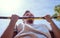 Young man doing pull ups outdoor summer day closeup